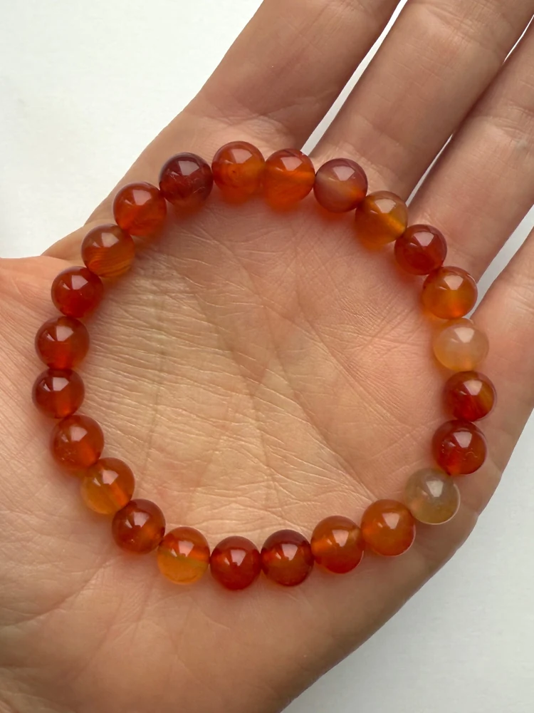 Orange carnelian bead bracelet resting in a hand