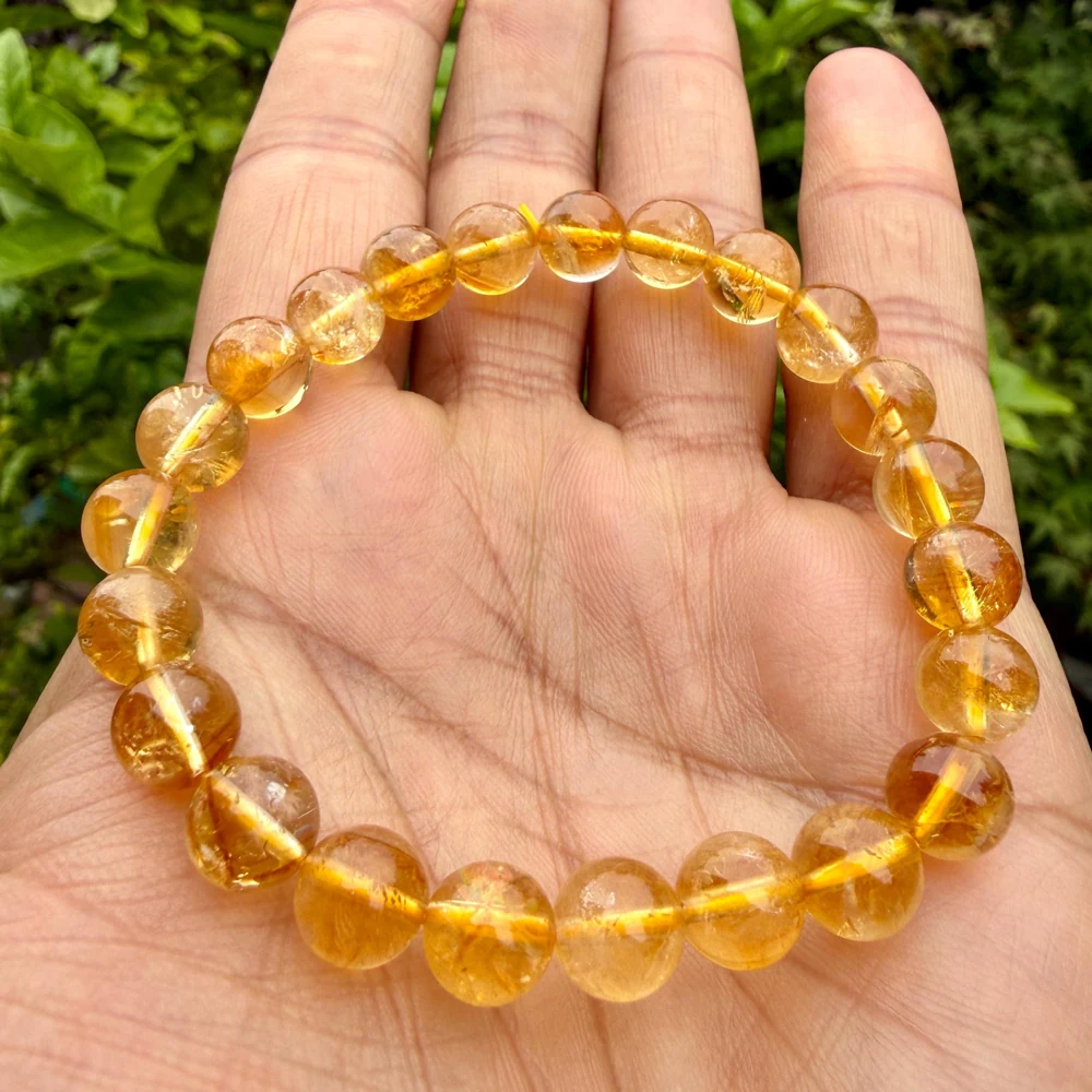 Golden citrine bead bracelet resting in a hand