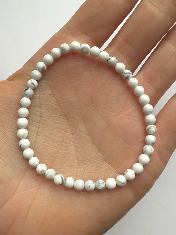 Small white howlite bead bracelet resting in a hand