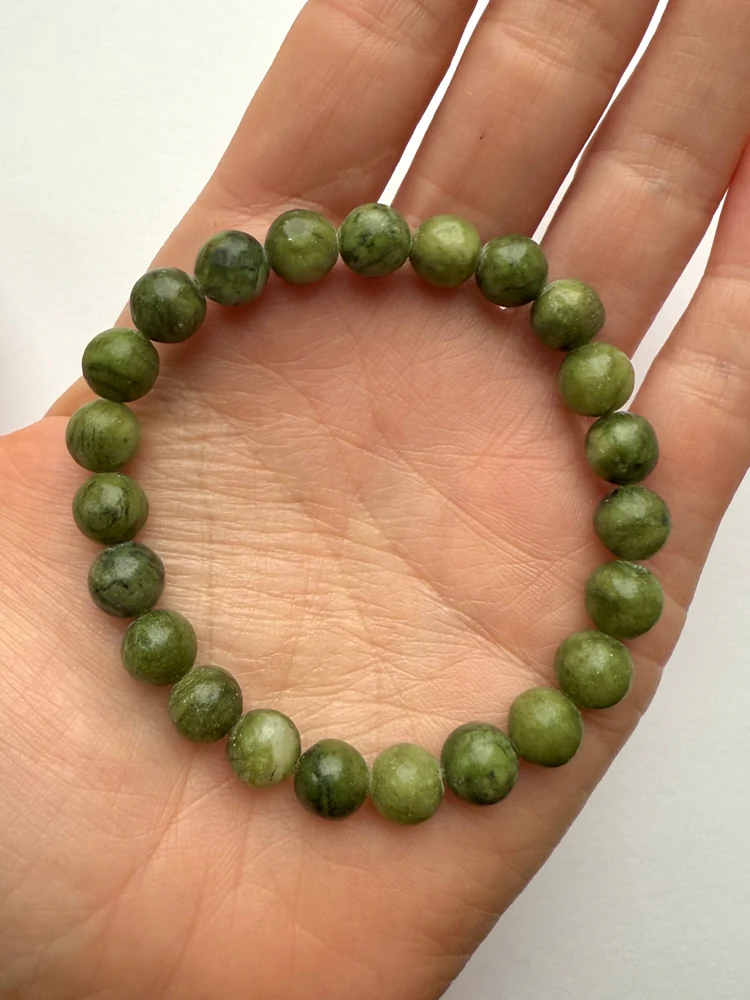 Green jade bead bracelet resting in a hand