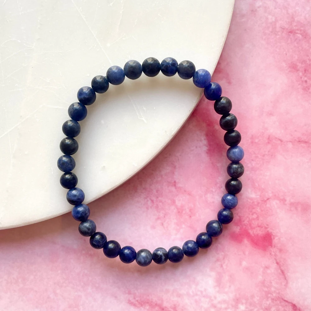Blue sodalite bead bracelet on a pink surface